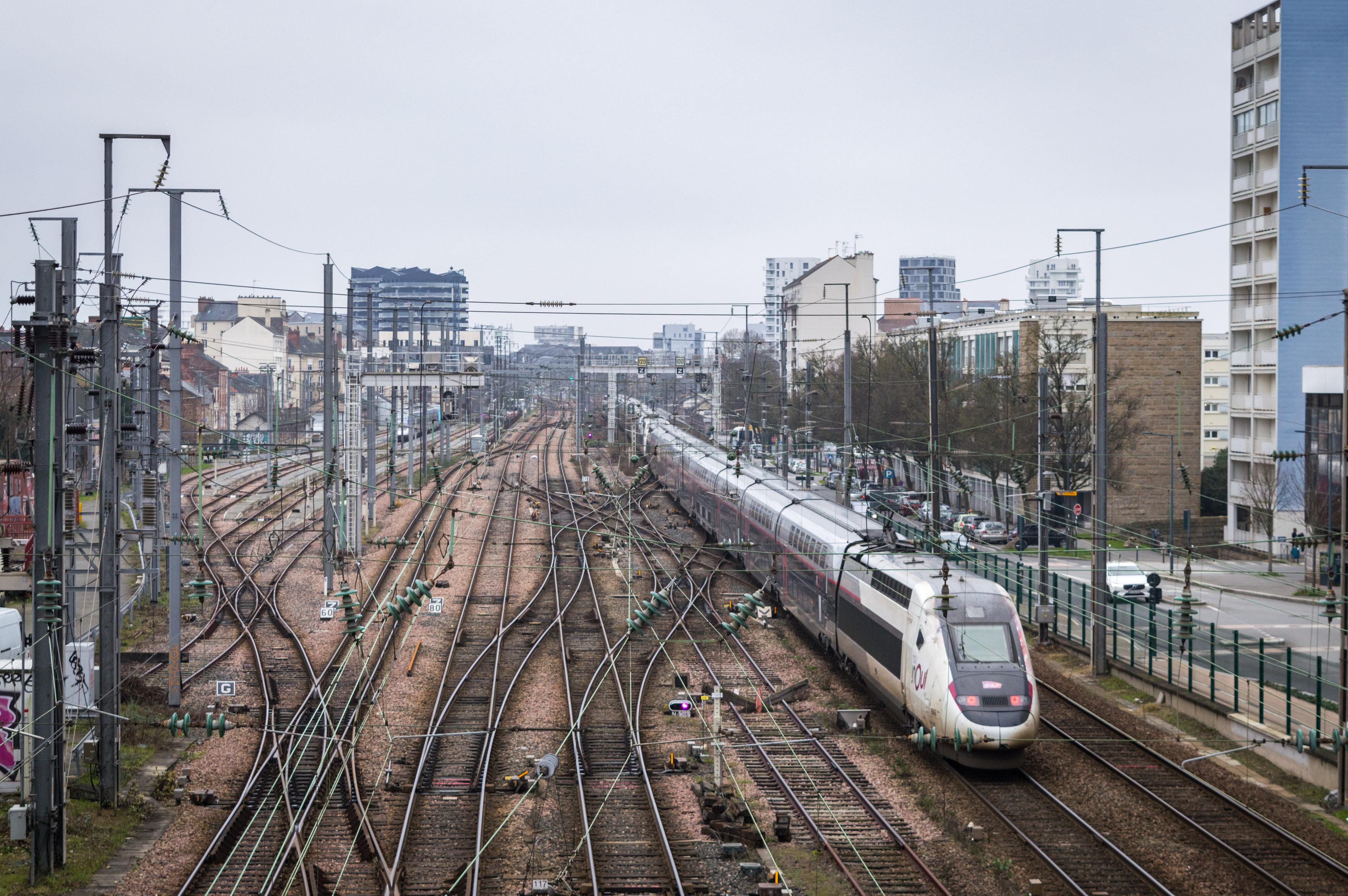 TGV Duplex on tracks right in front of the Rennes train station shot from a bridge over the tracks